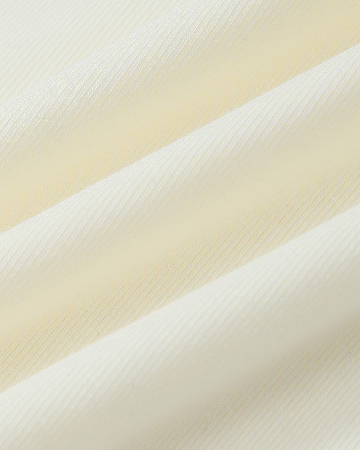 Close-up of the IVORY BAERAE T-SHIRT by Sundae School, featuring cream-colored ribbed fabric with soft diagonal folds and textured shadows, inspired by the traditional Korean durumagi overcoat.
