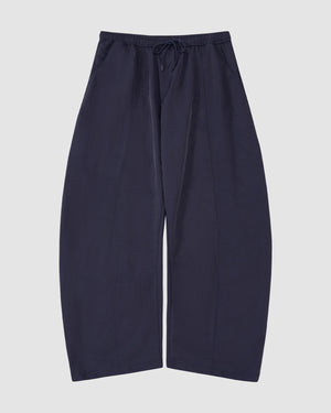 The Sundae School NAVY HANBOK BALLOON TRACK PANTS are loose-fitting, wide-leg navy nylon track pants with an elastic waistband, drawstring, and adjustable hems, shown against a plain light background.