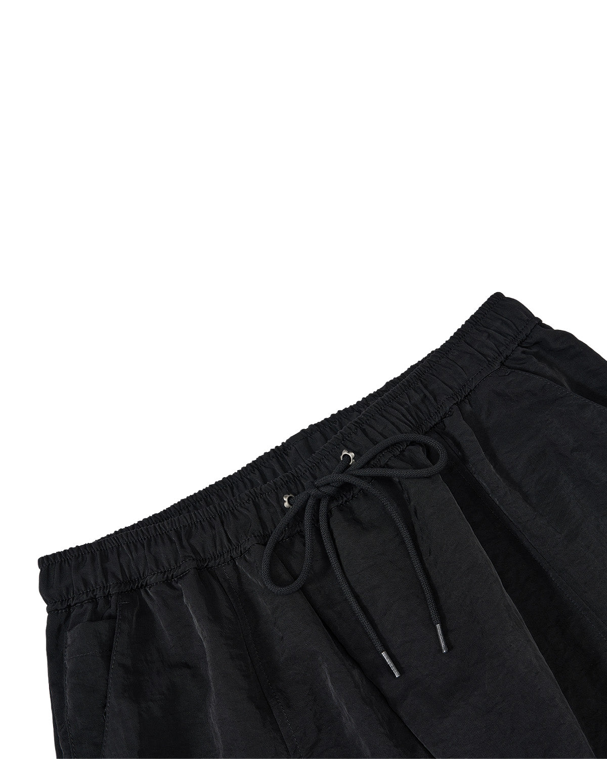 Close-up of black drawstring pants showing the elastic waistband and drawstring details against a plain white background.