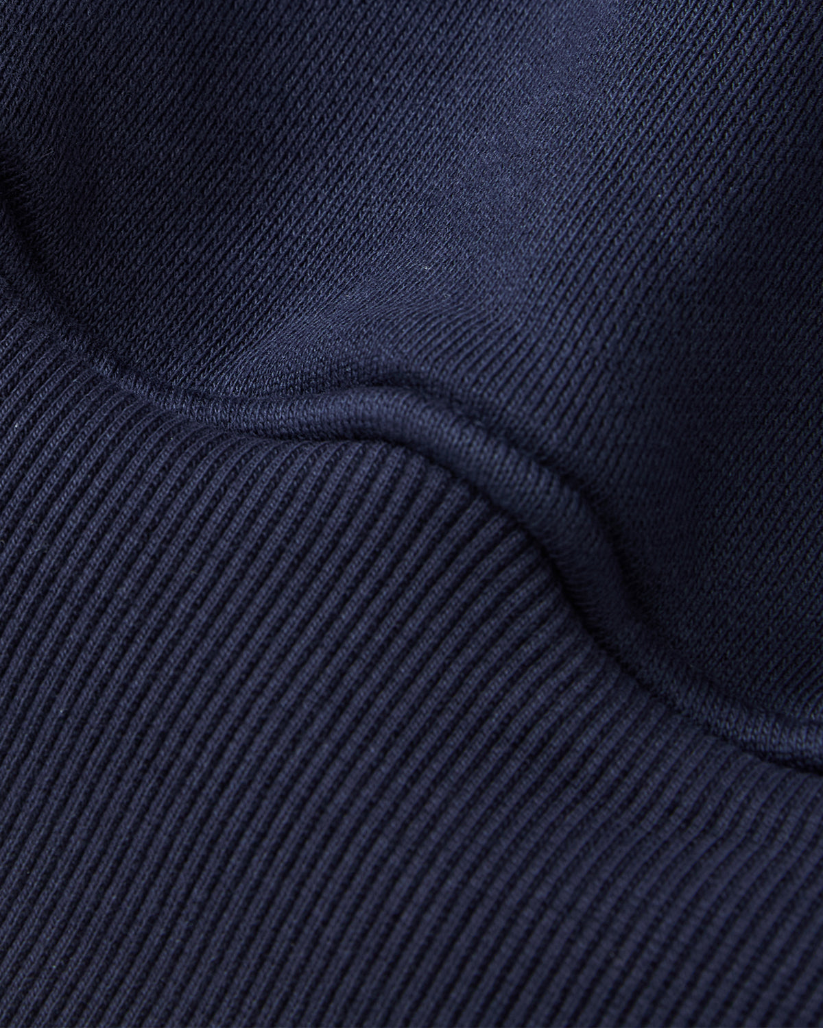 A close-up of the Sundae School NAVY HESTER QUARTER ZIP highlights the dark blue ribbed fabric's detailed texture and stitching.