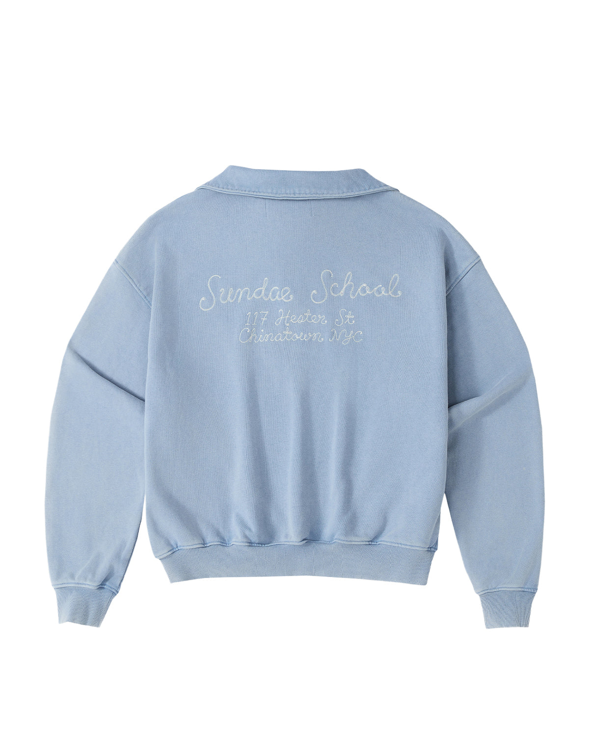The SKY BLUE HESTER QUARTER ZIP by Sundae School is an oversized, vintage-inspired cotton pullover sweatshirt in light blue. It features a quarter zip with a funnel neck collar, long sleeves, ribbed cuffs and hem, and white embroidery on the back that reads “Sundae School, 117 Hester St, Chinatown NYC.”.