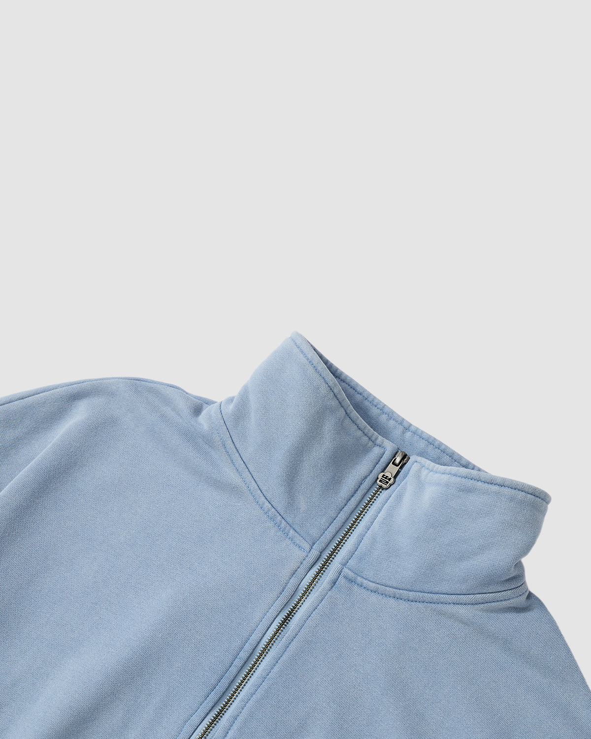 The SKY BLUE HESTER QUARTER ZIP by Sundae School features an oversized fit and high collar with a front zipper, shown on a plain white background. The image highlights the collar and zipper for a cozy, vintage-inspired look.