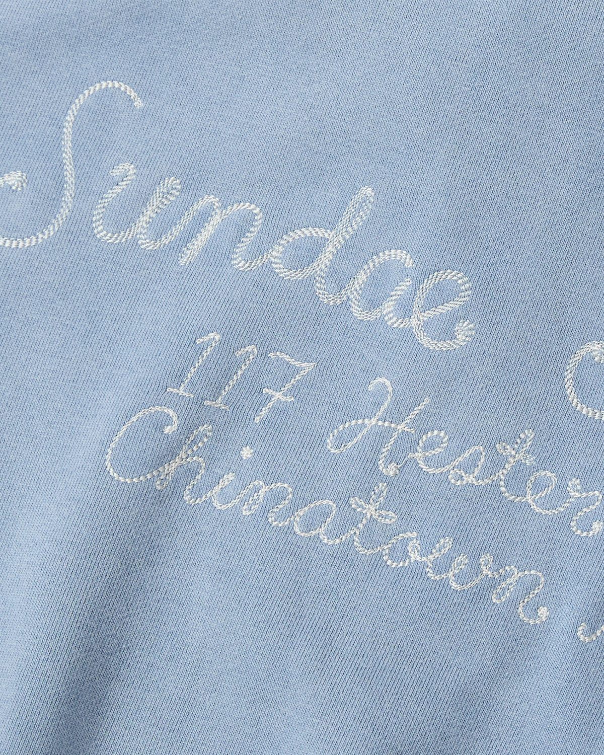 Check out the Sundae School SKY BLUE HESTER QUARTER ZIP—a vintage-inspired cotton pullover in light blue, featuring a funnel neck collar and white embroidered cursive text that reads: Sundae, 117 Hester, and Chinatown.