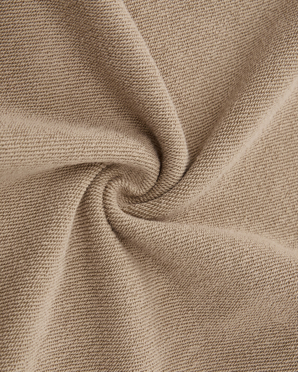 Close-up of taupe knitted fabric spiraled to showcase texture and weave—an inspiration for our Sundae School TAUPE HANBOK HOODIE with asymmetric hood closure and signature sleeve stash pocket.