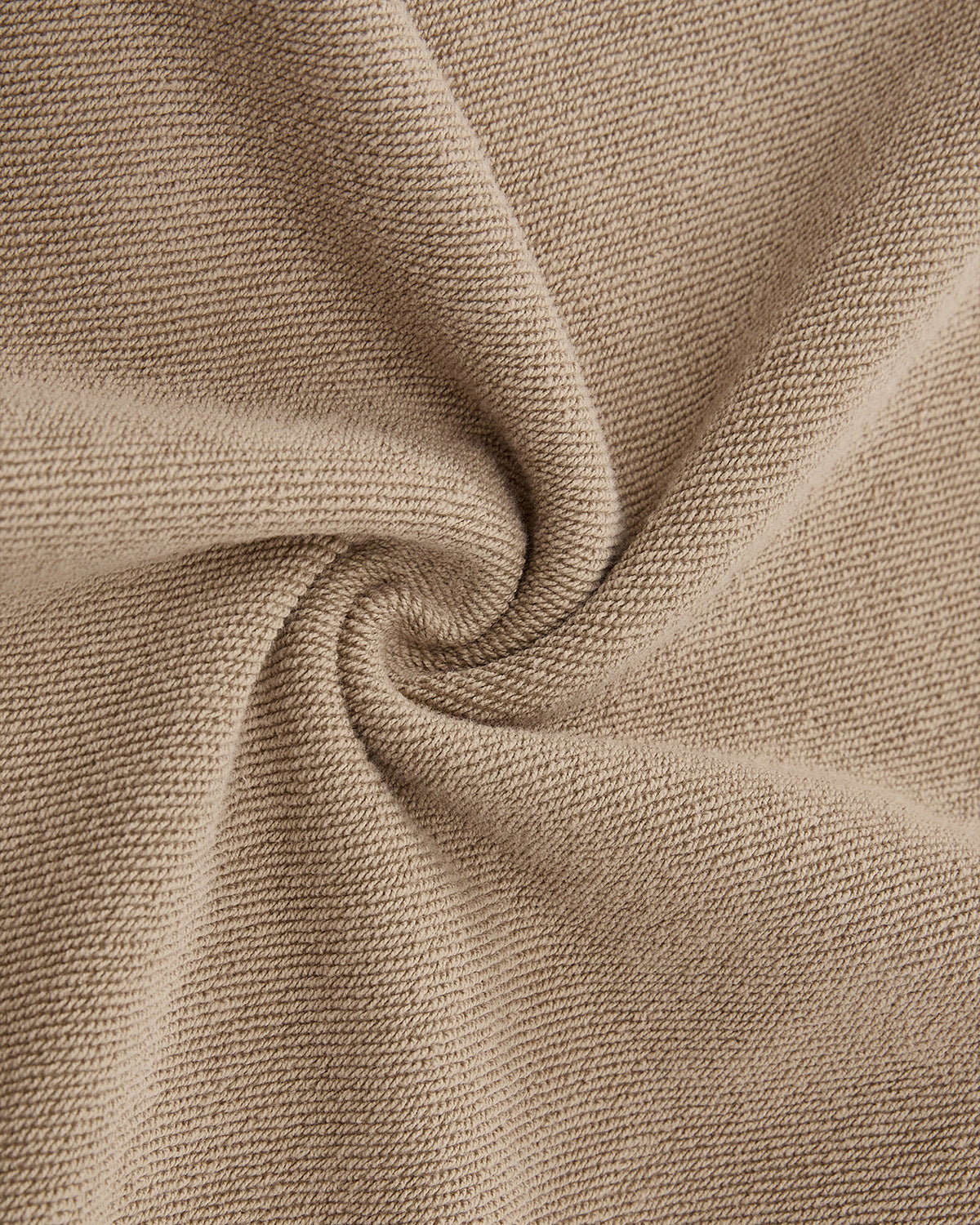 Close-up of taupe knitted fabric spiraled to showcase texture and weave—an inspiration for our Sundae School TAUPE HANBOK HOODIE with asymmetric hood closure and signature sleeve stash pocket.