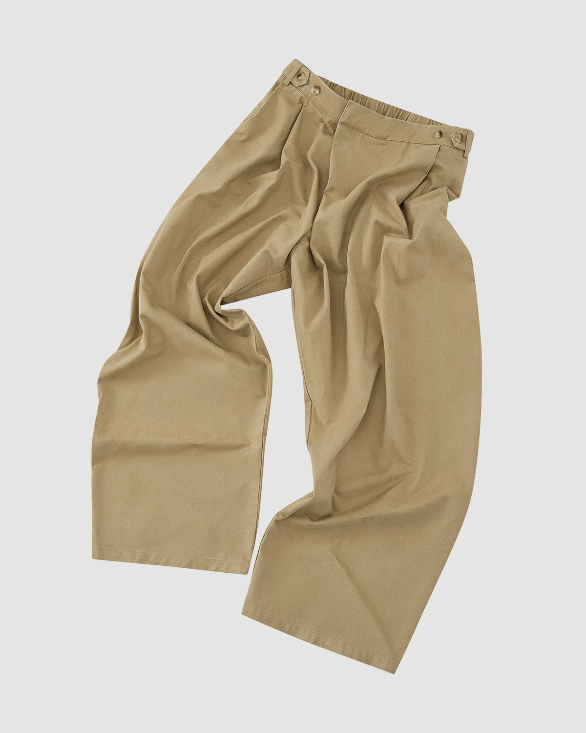 The OLIVE HANBOK CHINO PANTS by Sundae School are loose-fitting, wide-legged chinos with pleated details and side-adjuster tabs, shown laid flat on a white background.
