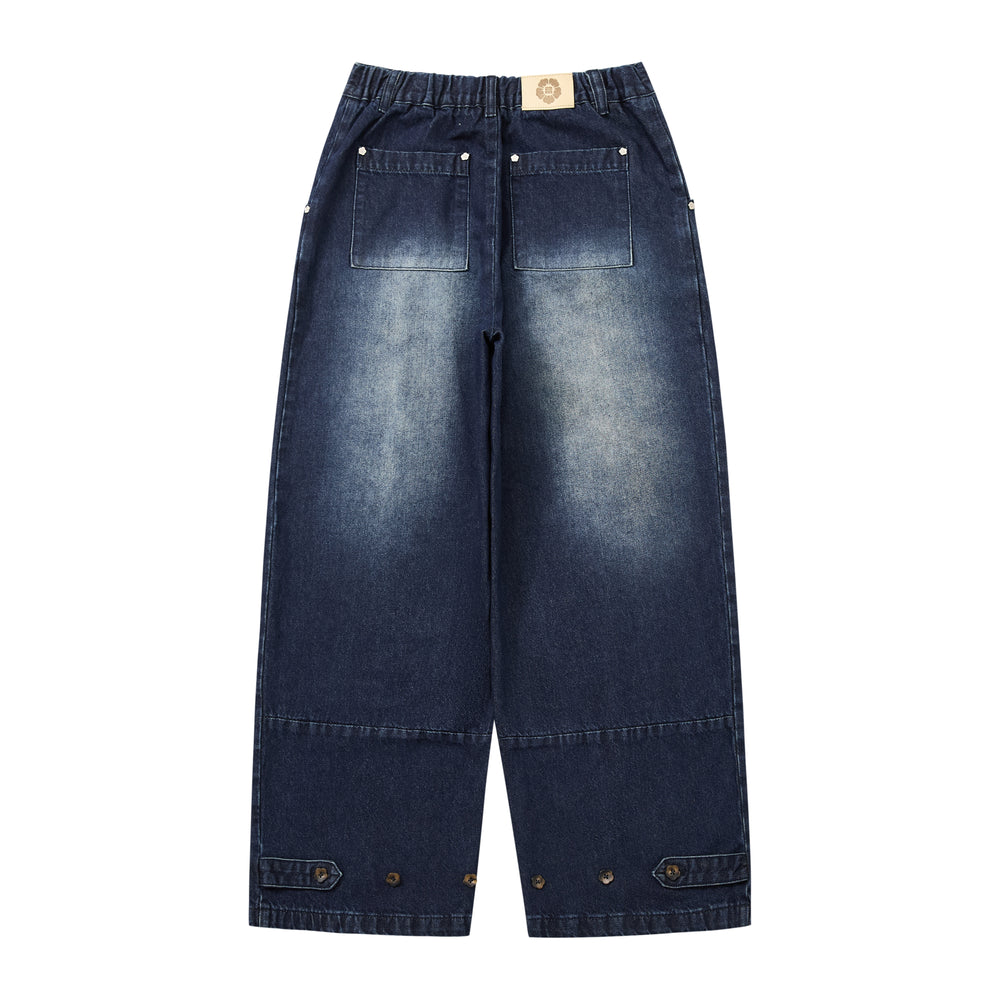 A pair of dark blue denim cropped pants with a high elastic waistband, front patch pockets, and buttoned flap details at the cuffs, shown against a plain white background.