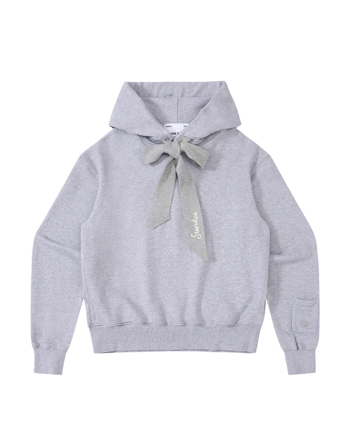 The HEATHER GREY KNIT TIE HOODIE by Sundae School is a light gray, heavyweight sweatshirt featuring a large knit bow at the neck, long sleeves, and ribbed cuffs and hem. Made from soft brushed cotton for extra comfort, this unisex hoodie is finished with “Salut” embroidered in cursive near the bow.