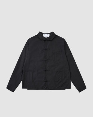 The Sundae School KNOT TIE TOWN JACKET is a black unisex quilted jacket with long sleeves, a mandarin collar, frog button closures inspired by Buddhist knots, chest and lower front pockets, shown on a light gray background.