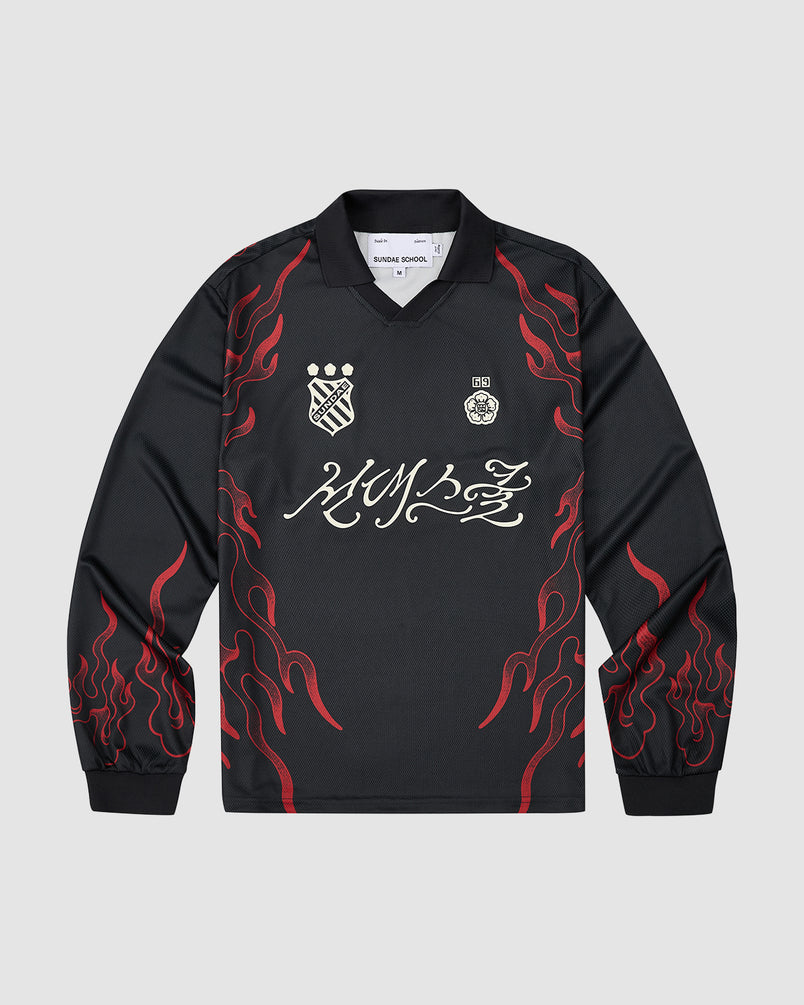 The Sundae School KOREATOWN FOOTBALL JERSEY is a black long-sleeve shirt with red flame graphics on the sleeves and sides, white embroidered chest logos, bold white script across the front, and custom Korean designs inspired by K-Town style.