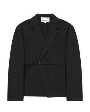 The Sundae School BLACK LINEN GORUM BLAZER is an unstructured black wrap-style blazer featuring a single button, left chest pocket, and a tie closure at the waist, displayed against a white background.