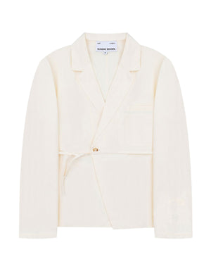 An ivory linen “Gorum Blazer” by Sundae School, featuring a single button closure, tied fabric belt, notched lapels, and a chest pocket. The label inside reads Sundae School.