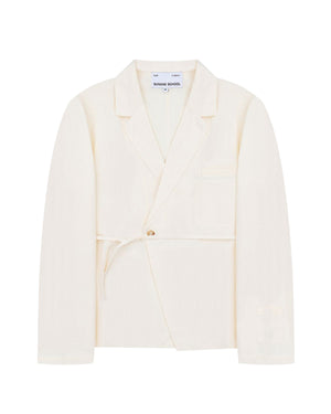 An ivory linen “Gorum Blazer” by Sundae School, featuring a single button closure, tied fabric belt, notched lapels, and a chest pocket. The label inside reads Sundae School.