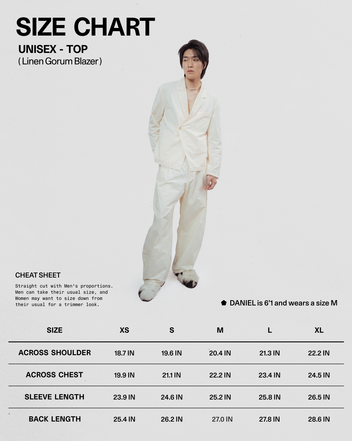 A person wearing the IVORY LINEN GORUM BLAZER and matching pants from Sundae School stands next to a size chart for this unisex linen blazer, which displays measurements for sizes XS to XL and notes that Daniel is 6'1