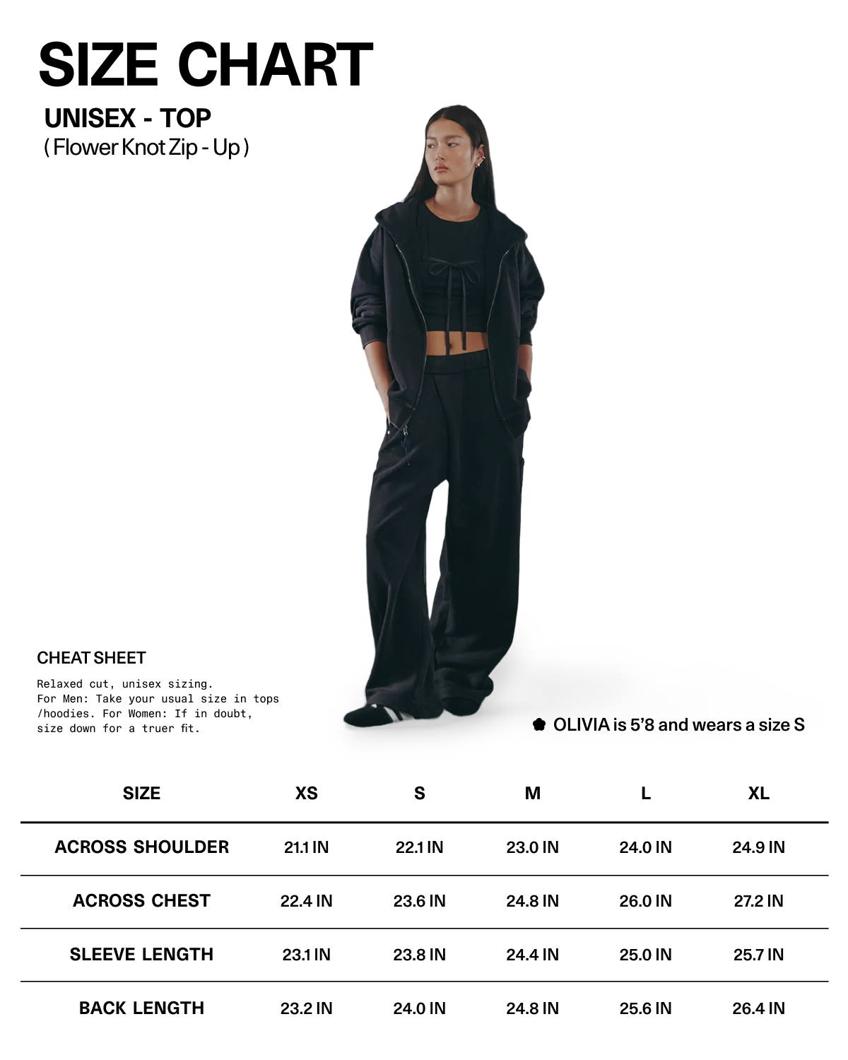 A woman wearing Sundae School’s BLACK WASH FLOWER KNOT ZIP UP stands beside a unisex top size chart displaying shoulder, chest, and length measurements for sizes XS to XL. She is 5'8