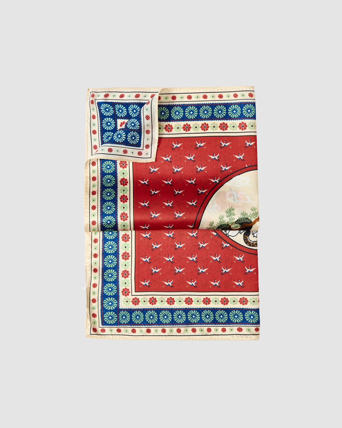 The Sundae School MINHWA BANDANA is inspired by Korean folk art, featuring a red base with white birds, blue and cream floral borders, and a detailed circle with a tree and animal—an ideal unique luxury gift.