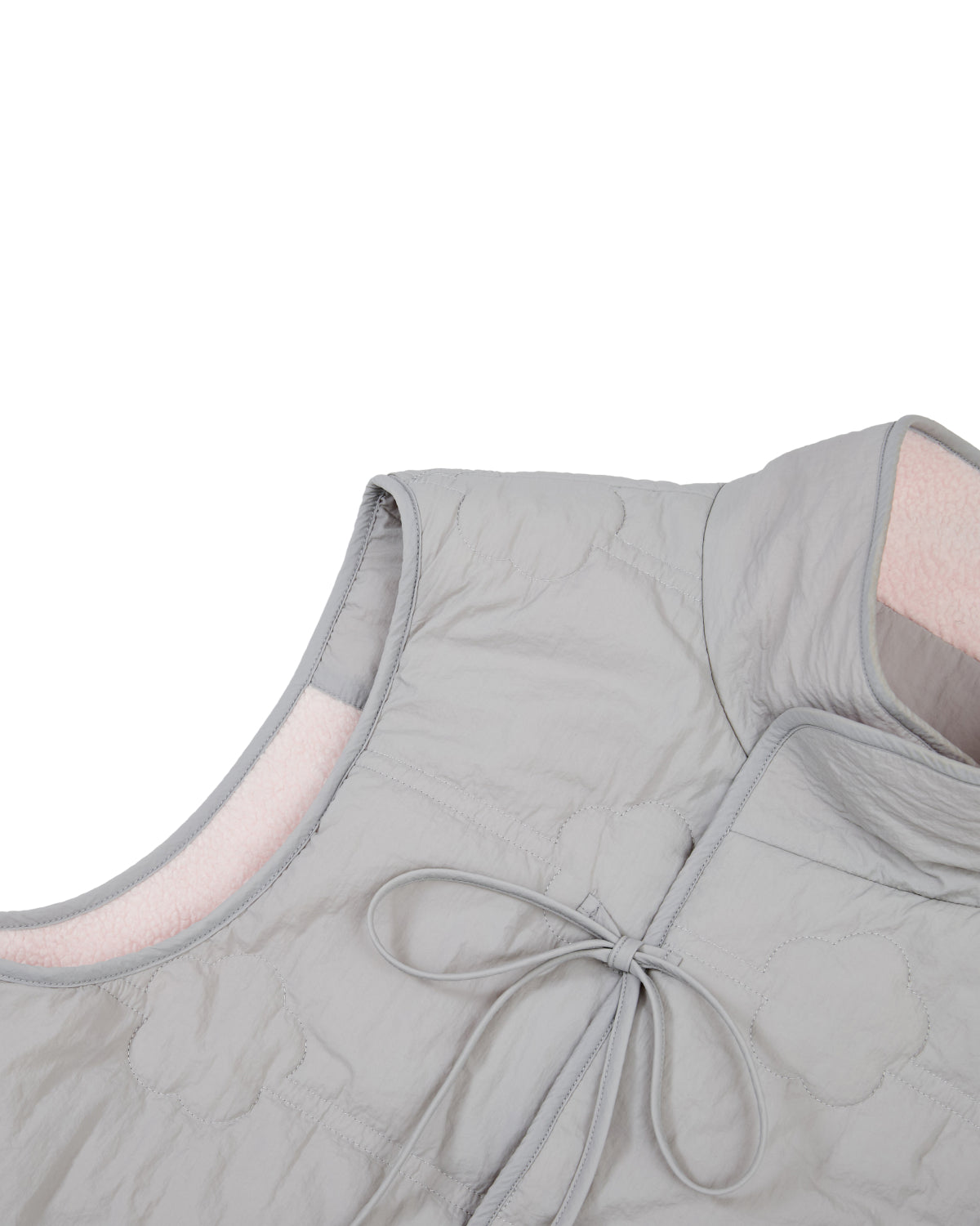 Close-up of the BABY PINK MOMO REVERSIBLE FLEECE VEST by Sundae School, featuring a light gray, sleeveless quilted design with a fabric tie at the front and soft pink lining visible inside the collar. The vest has a simple, elegant style and is photographed against a white background.