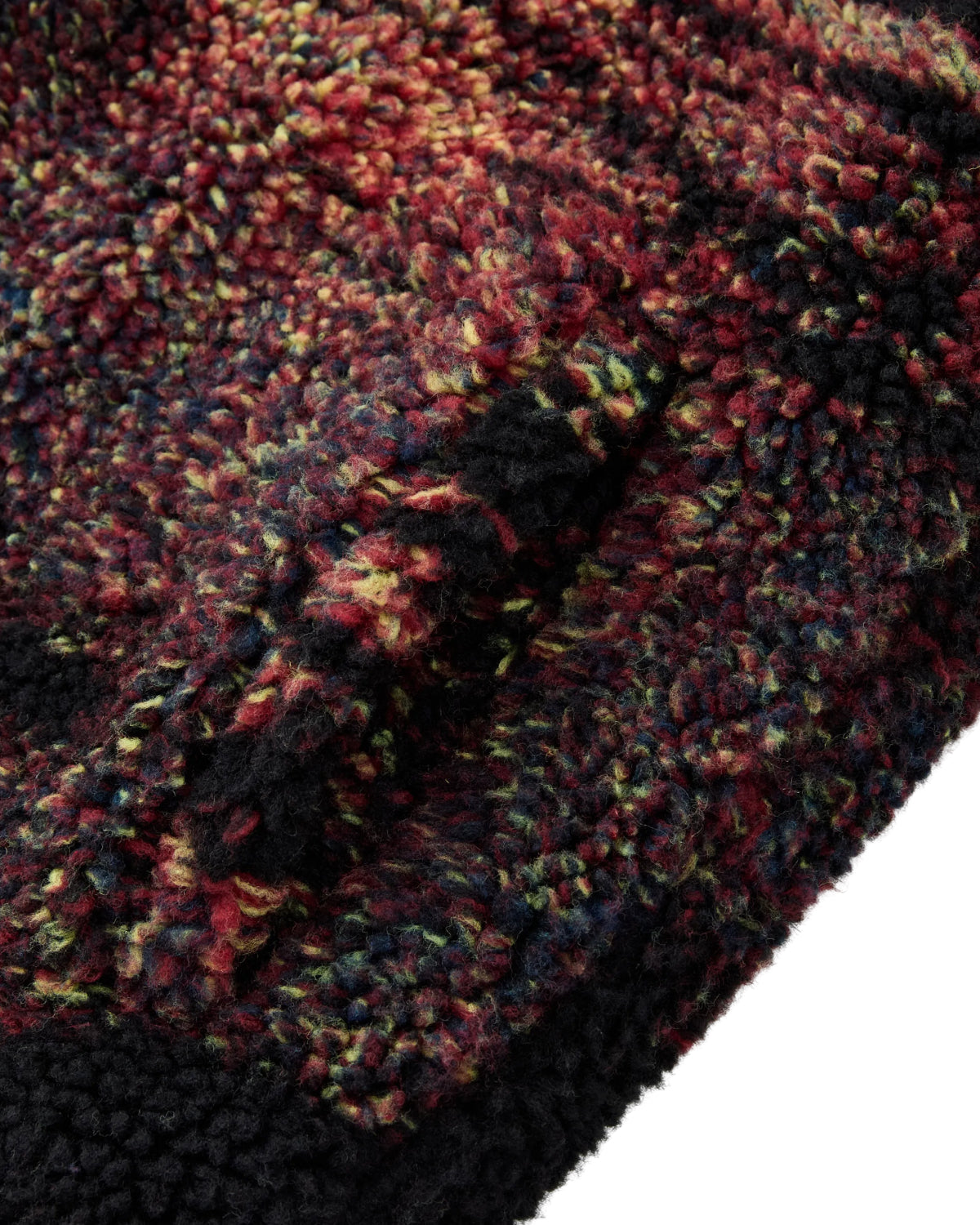 Close-up of Sundae School’s New Toker Fleece, a high-pile sherpa fabric with a soft and fuzzy surface, featuring a multicolored texture in shades of red, yellow, green, and black.
