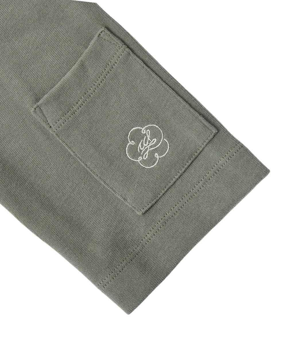 A close-up of the Sundae School KHAKI OFFICE QUARTER ZIP’s green cotton jersey sleeve, featuring a small rectangular stash pocket and a white embroidered logo with a decorative design.