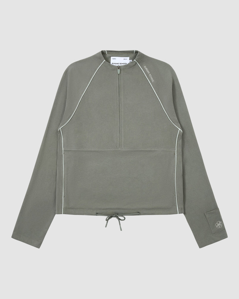 The Sundae School Khaki Office Quarter Zip is a cotton jersey pullover in olive green with white piping, ribbed texture, quarter-zip front, drawstring hem, left sleeve logo, stash pocket, and modern minimalist design.
