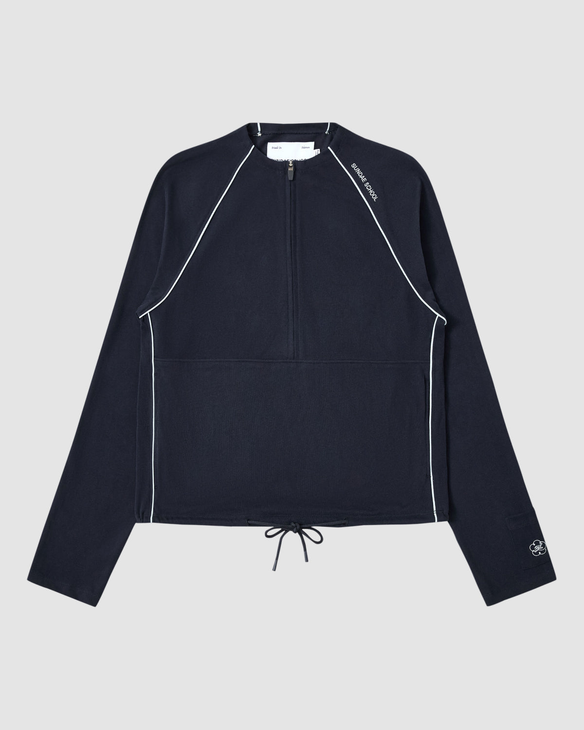 The NAVY OFFICE QUARTER ZIP by Sundae School is a navy cotton jersey long-sleeve pullover featuring white piping, a quarter-zip front, drawstring hem, stash pocket, and subtle white logos on the collar and sleeve. Displayed flat on light gray.