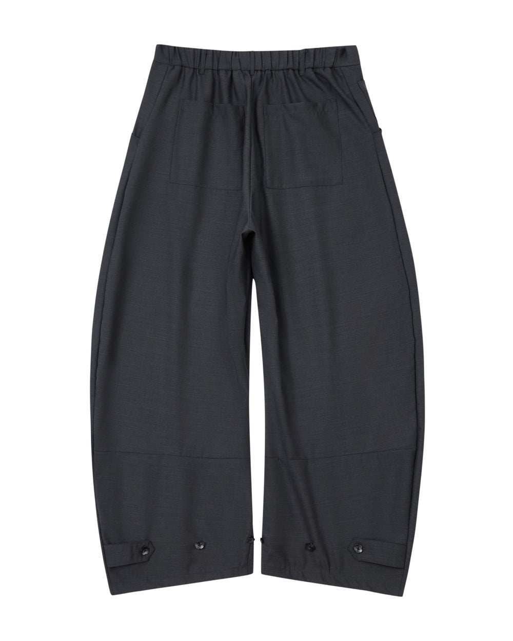 CHARCOAL PLEATED HANBOK SLACKS by Sundae School, featuring a wide-leg silhouette in black with pleated detailing, an elastic waistband, two back pockets, and adjustable button tabs at the ankles, laid flat on a white background.