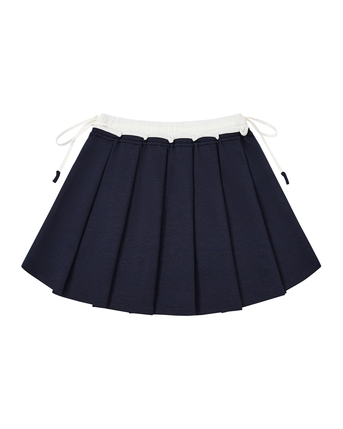 The NAVY PLEATED JERSEY MINI SKIRT by Sundae School, featuring a navy blue knife-pleated design with a contrasting white waistband and side drawstrings, is crafted from a soft cotton blend jersey and displayed flat on a white background.