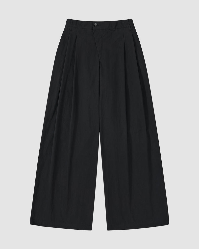Sundae School's BLACK PLEATED UNIFORM SLACKS are unisex, high-waisted, with a wide-leg fit, front pleats, and button-zipper closure, inspired by Korean school uniforms and shown on a plain white background.