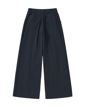Sundae School NAVY PLEATED UNIFORM SLACKS feature a wide-leg fit, elastic waistband, and side pockets. Shown flat on a white background in back view, these slacks give a modern update to classic Korean gyobok style.
