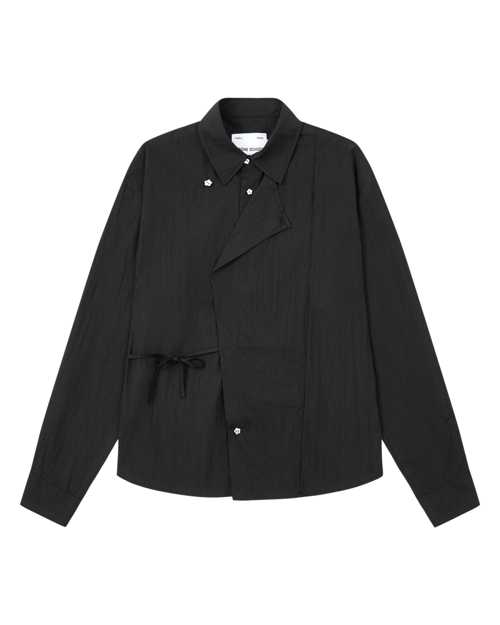 Introducing the BLACK POPLIN TIE GORUM SHIRT by Sundae School: a black long-sleeve, unisex tailored-fit shirt crafted from crisp cotton-nylon poplin. Featuring a unique asymmetric front with snap buttons and side tie detail, this modern yet timeless piece is laid flat against a white background, blending contemporary design with lasting comfort.