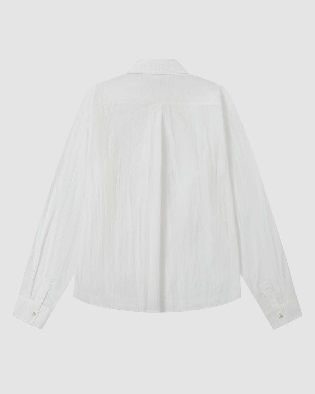 The WHITE POPLIN TIE GORUM SHIRT by Sundae School is displayed from the back on a flat surface, showcasing its collar and buttoned cuffs.