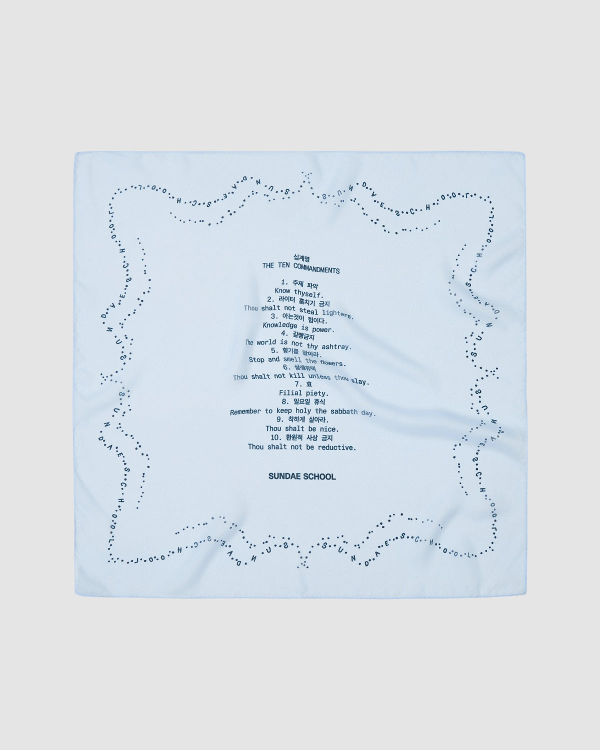 The SKY BLUE 10 COMMANDMENTS ORGANZA BANDANA by Sundae School is a sheer, light blue square scarf with a dotted border and center print featuring a stylized Ten Commandments list and 