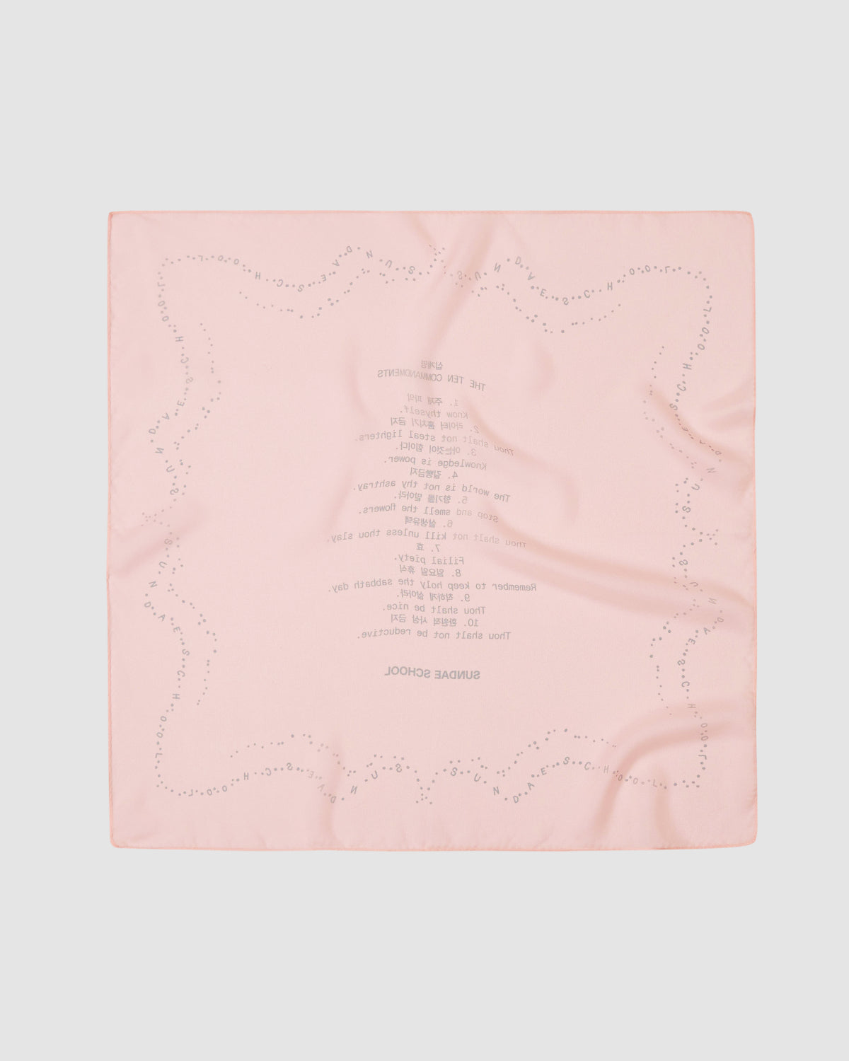 The Sundae School BABY PINK 10 COMMANDMENTS ORGANZA BANDANA features pale pink silk organza with subtle dot borders and an upside-down Ten Commandments print, shown laid flat on a light gray background.