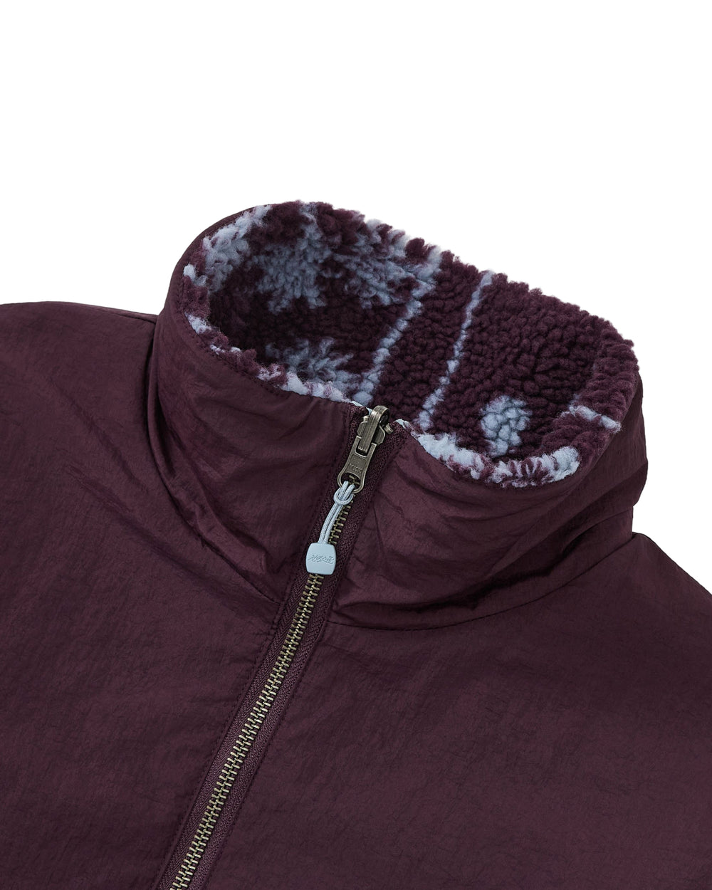 Close-up of the Sundae School PLUM REVERSIBLE GOSTOP FLEECE, a maroon hwatu jacket with a stand collar zip-up front and a high collar lined with purple and white patterned reversible sherpa fleece.
