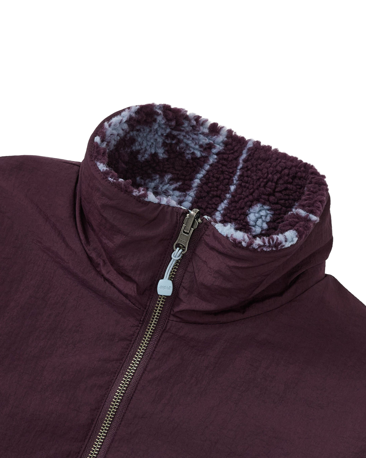 Close-up of the Sundae School PLUM REVERSIBLE GOSTOP FLEECE, a maroon hwatu jacket with a stand collar zip-up front and a high collar lined with purple and white patterned reversible sherpa fleece.