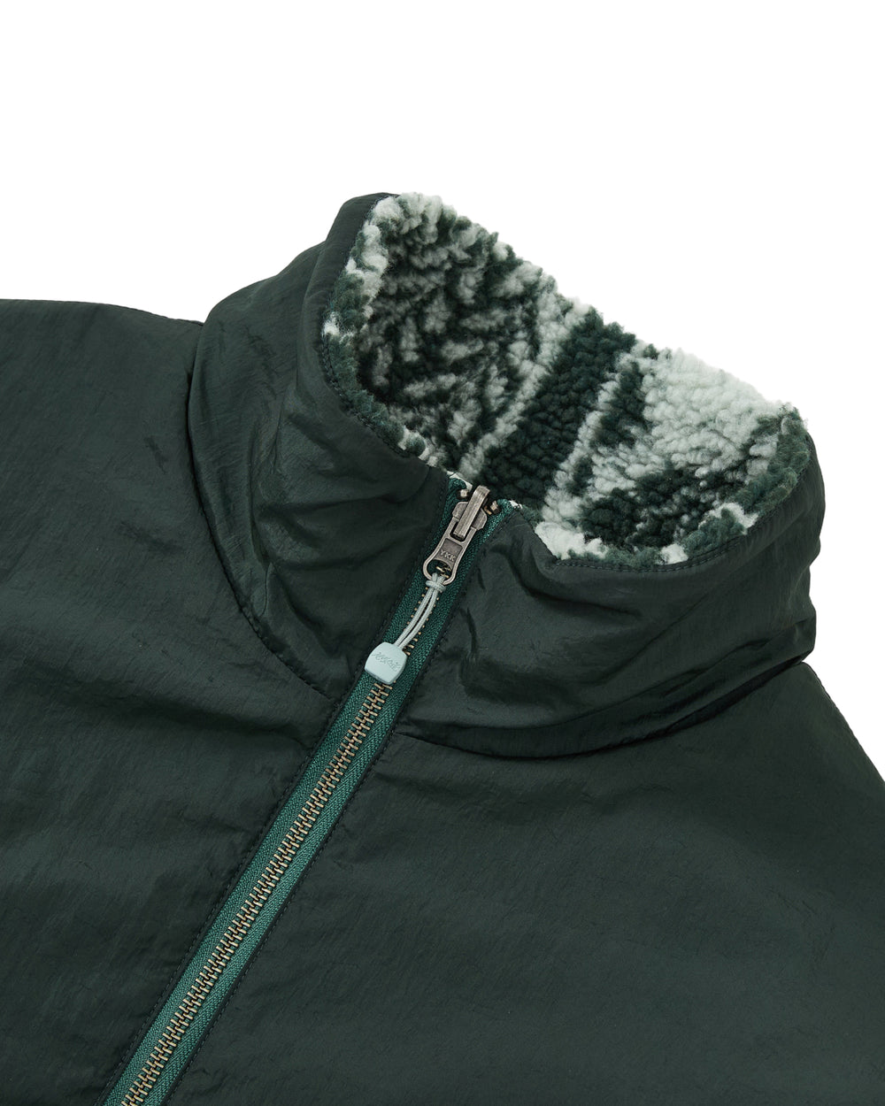 Close-up of the Sundae School TEAL REVERSIBLE GOSTOP FLEECE jacket, showcasing a stand collar zip up and a soft, light and dark gray patterned reversible sherpa fleece lining on the collar.