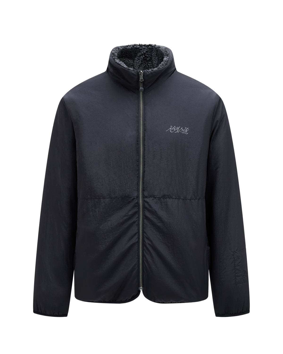 Introducing the BLACK REVERSIBLE IREZUMI FLEECE by Sundae School: a black zip-up jacket with a high collar, crafted with a soft, textured jacquard fleece inner lining and detailed with subtle white logo embroidery on the left chest. This reversible design delivers versatile style, ensuring both functionality and fashion.