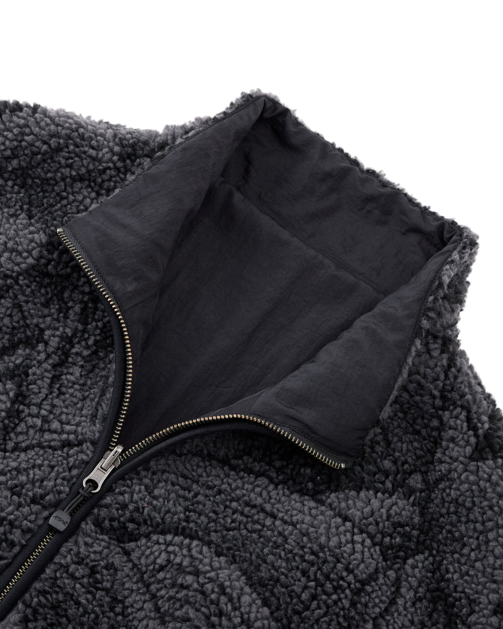 Close-up of the Sundae School BLACK REVERSIBLE IREZUMI FLEECE, featuring a dark gray jacquard texture, high collar, and a partially unzipped metal zipper that reveals the smooth inner lining.