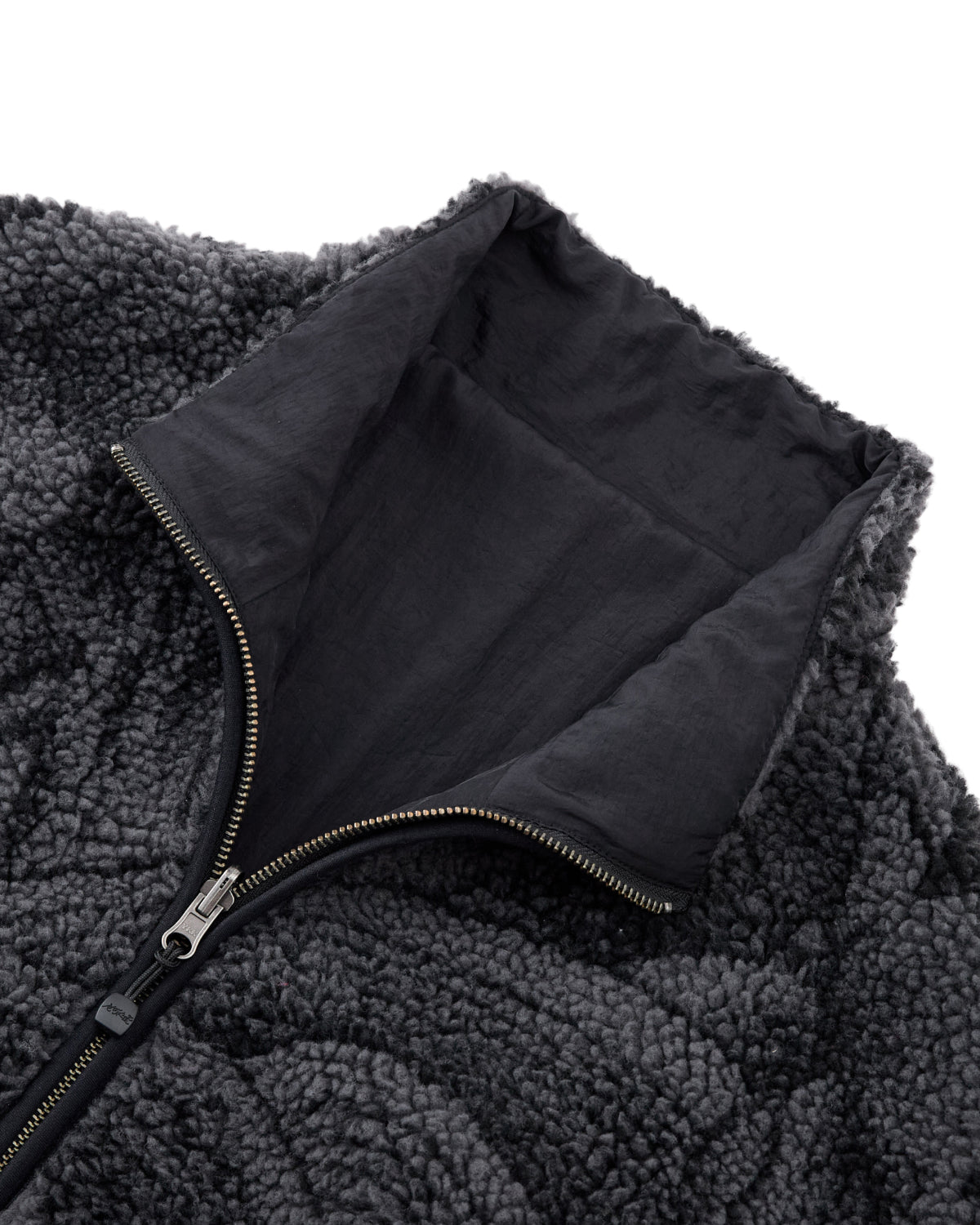 Close-up of the Sundae School BLACK REVERSIBLE IREZUMI FLEECE, featuring a dark gray jacquard texture, high collar, and a partially unzipped metal zipper that reveals the smooth inner lining.