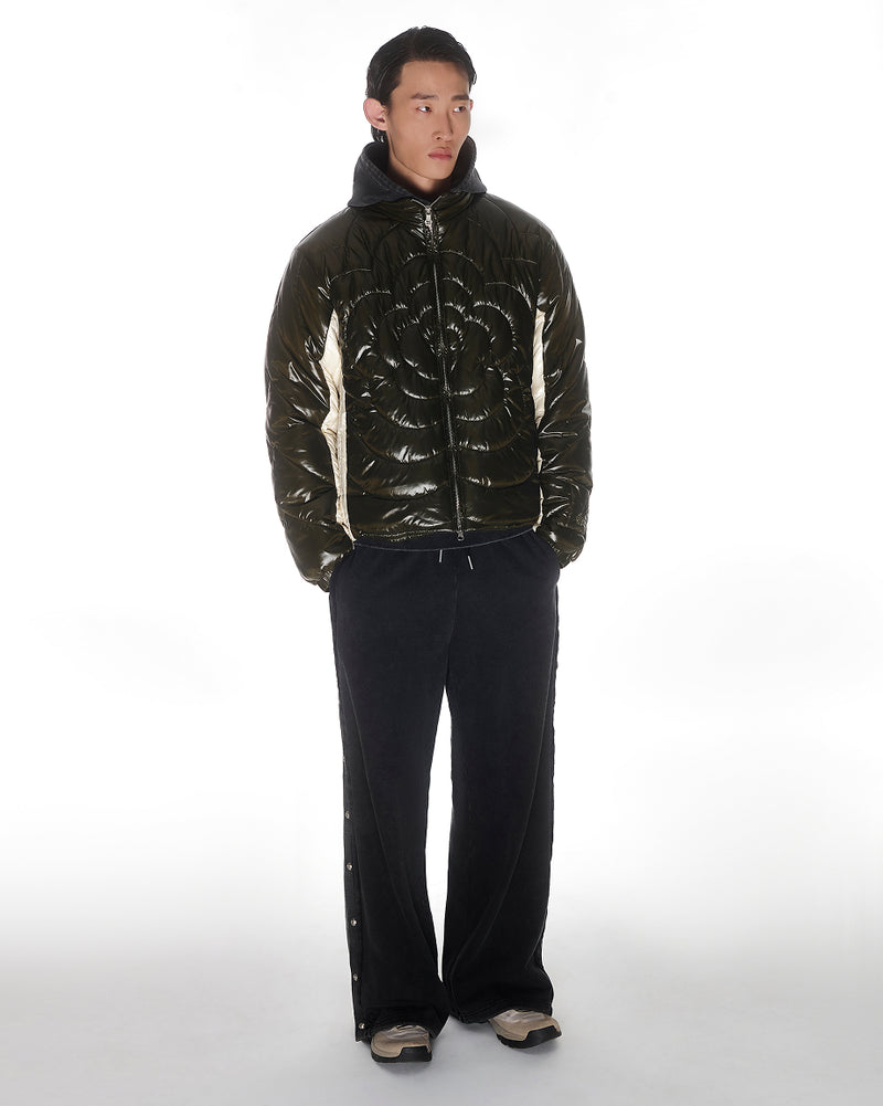A model wearing Sundae School Olive Mochi Spiral Puffer in front of a white backround.