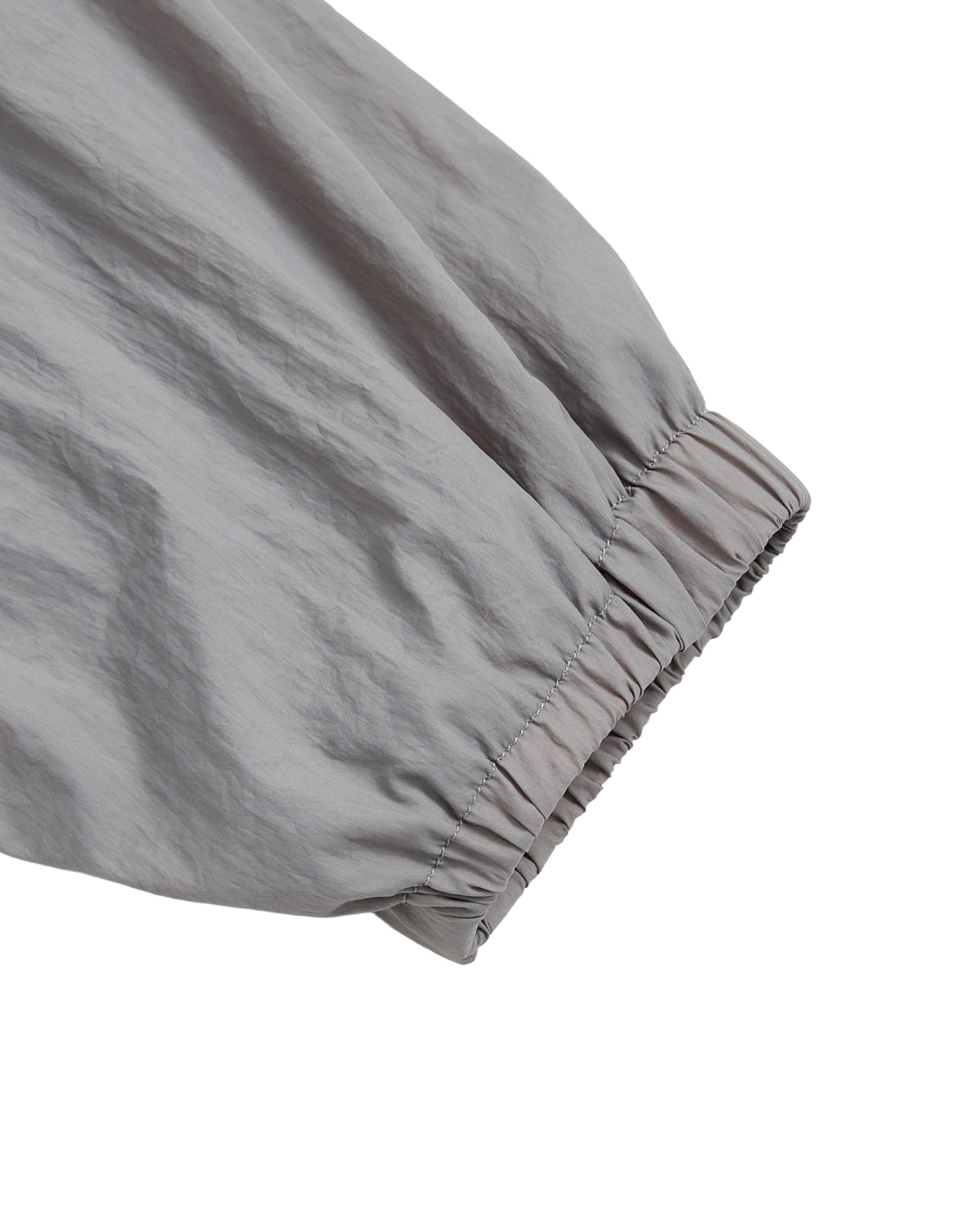 A close-up of the GREY SAILOR WINDBREAKER by Sundae School, featuring an elastic cuff and lightweight, slightly wrinkled fabric—perfect for a cropped windbreaker or UV protection jacket.