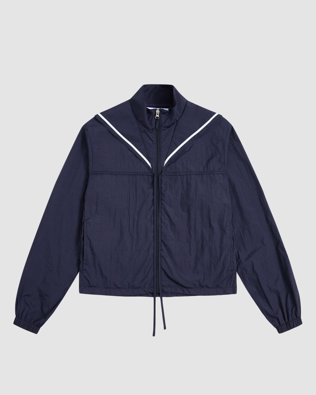 The Sundae School NAVY SAILOR WINDBREAKER is a navy cropped jacket with a high collar, long sleeves, elastic cuffs, and V-shaped white piping on the chest, shown laid flat on a light gray background.