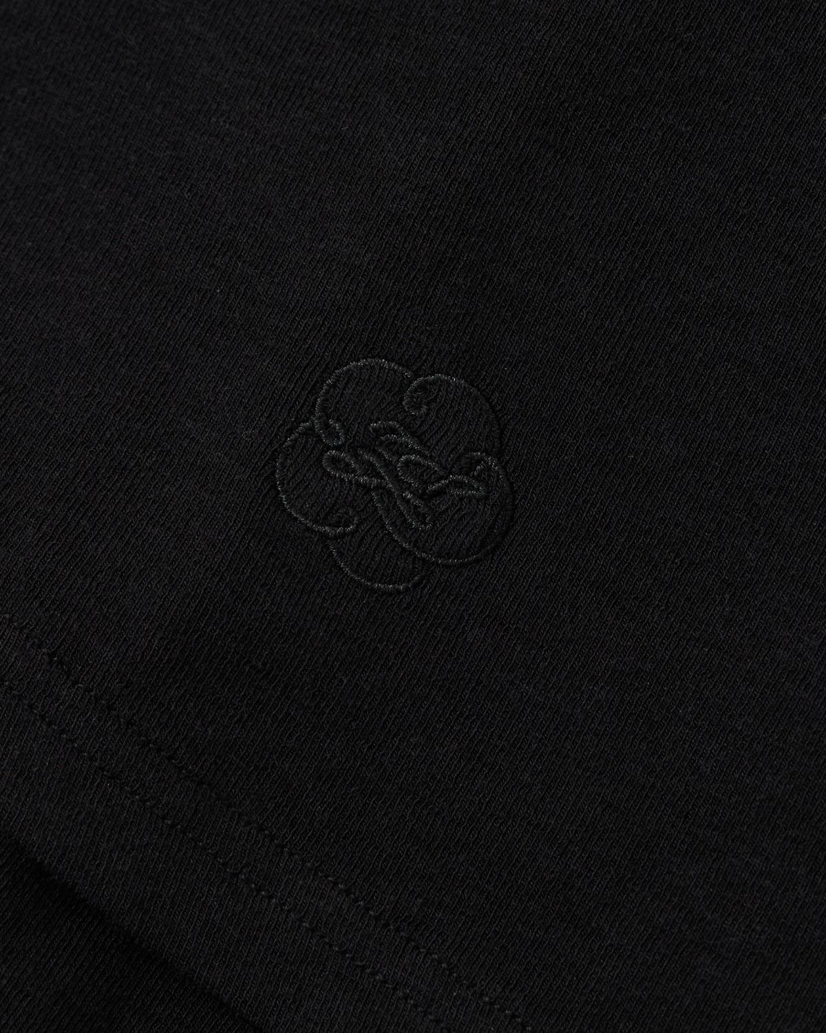 BLACK SEONGSU APRON PANTS in black fabric with a wide-leg silhouette and an embroidered tonal floral design in the center.