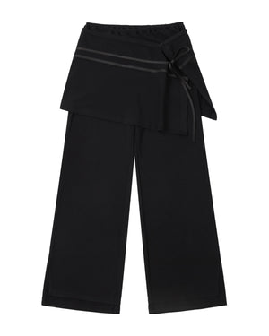 BLACK SEONGSU APRON PANTS: black wide-leg trousers featuring a hybrid wrap skirt front that ties at the side with a ribbon.