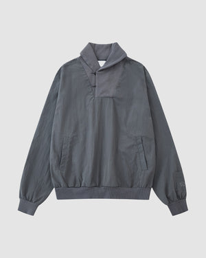 The CHARCOAL SHAWL COLLAR ANORAK by Sundae School features long sleeves, a shawl collar, ribbed cuffs and hem, side pockets, and a chest V-seam detail inspired by monk-core style.