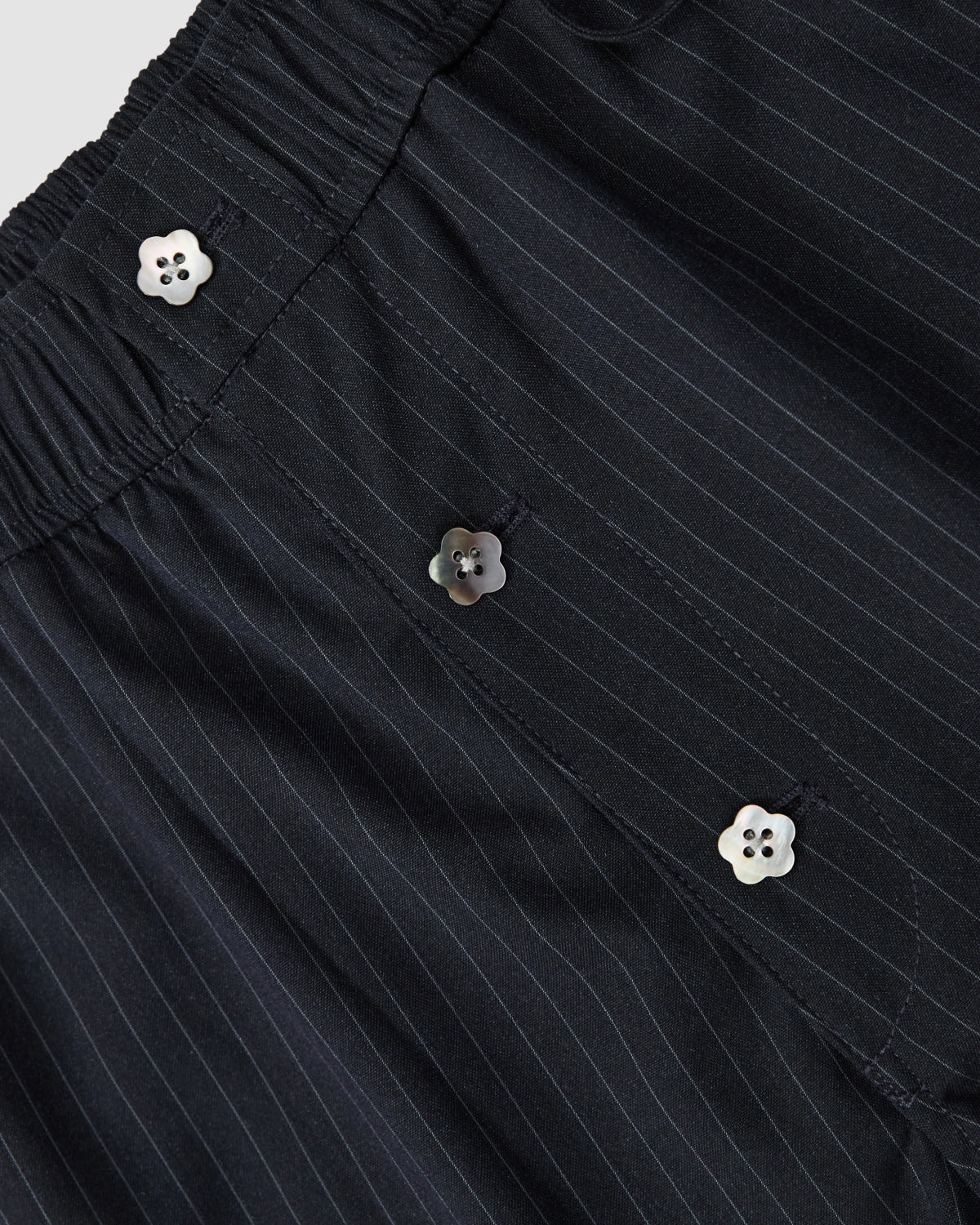 Close-up of Sundae School’s NAVY STRIPE BOXER SHORTS, crafted in a soft Tencel-rayon blend with an elastic waistband and three flower-shaped buttons on the placket.