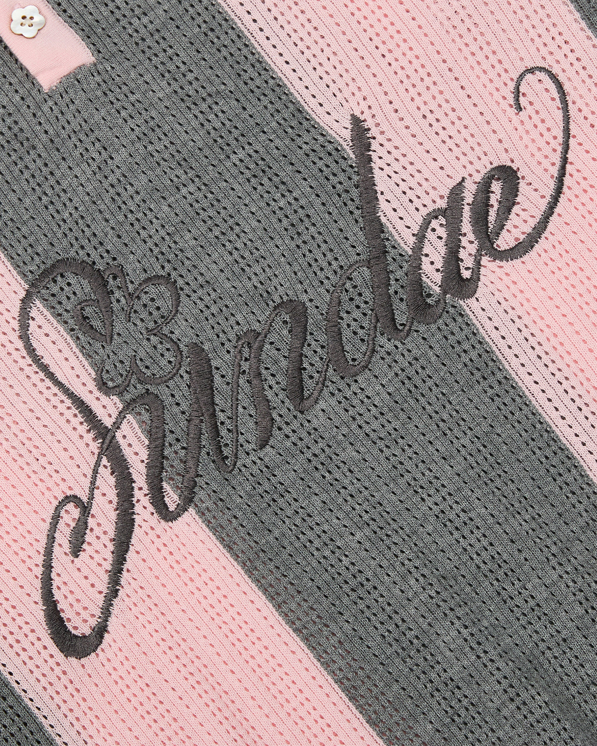 Close-up of Sundae School's PINK SUNDAE SOCCER JERSEY, a 100% cotton lightweight top with textured pink and gray stripes, black cursive 