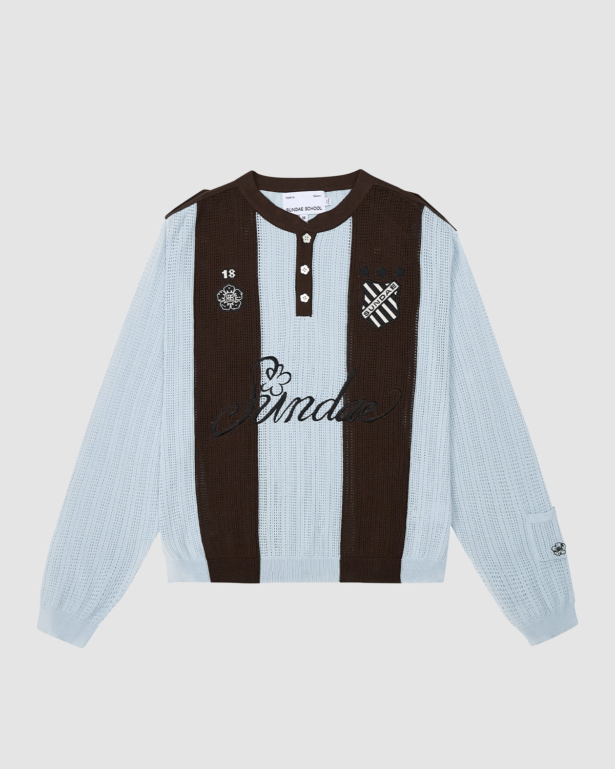 The SKY BLUE SUNDAE SOCCER JERSEY by Sundae School is a long-sleeve cotton knit polo with light blue and dark brown stripes, black collar and buttons, and embroidered B crest, 18, skull, and 