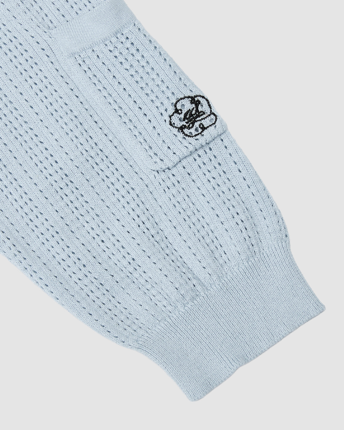 The SKY BLUE SUNDAE SOCCER JERSEY by Sundae School is a light blue cotton knit with ribbed pattern, a small pocket, and a black embroidered smiley face near the pocket.