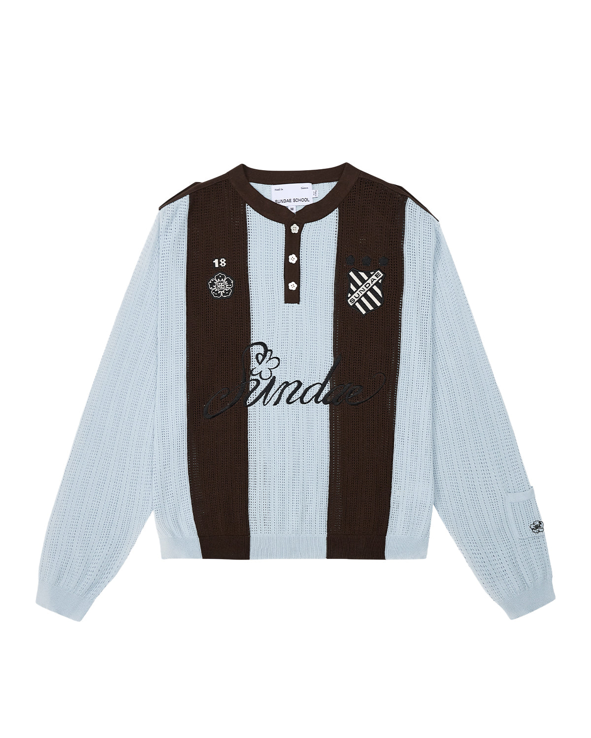 Sundae School SKY BLUE SUNDAE SOCCER JERSEY: This light blue and brown long-sleeve knit jersey features vertical stripes, a buttoned collar with unique floral mochi buttons, and embroidered chest patches—including a skull, heart, and “Banda” text—across the front.